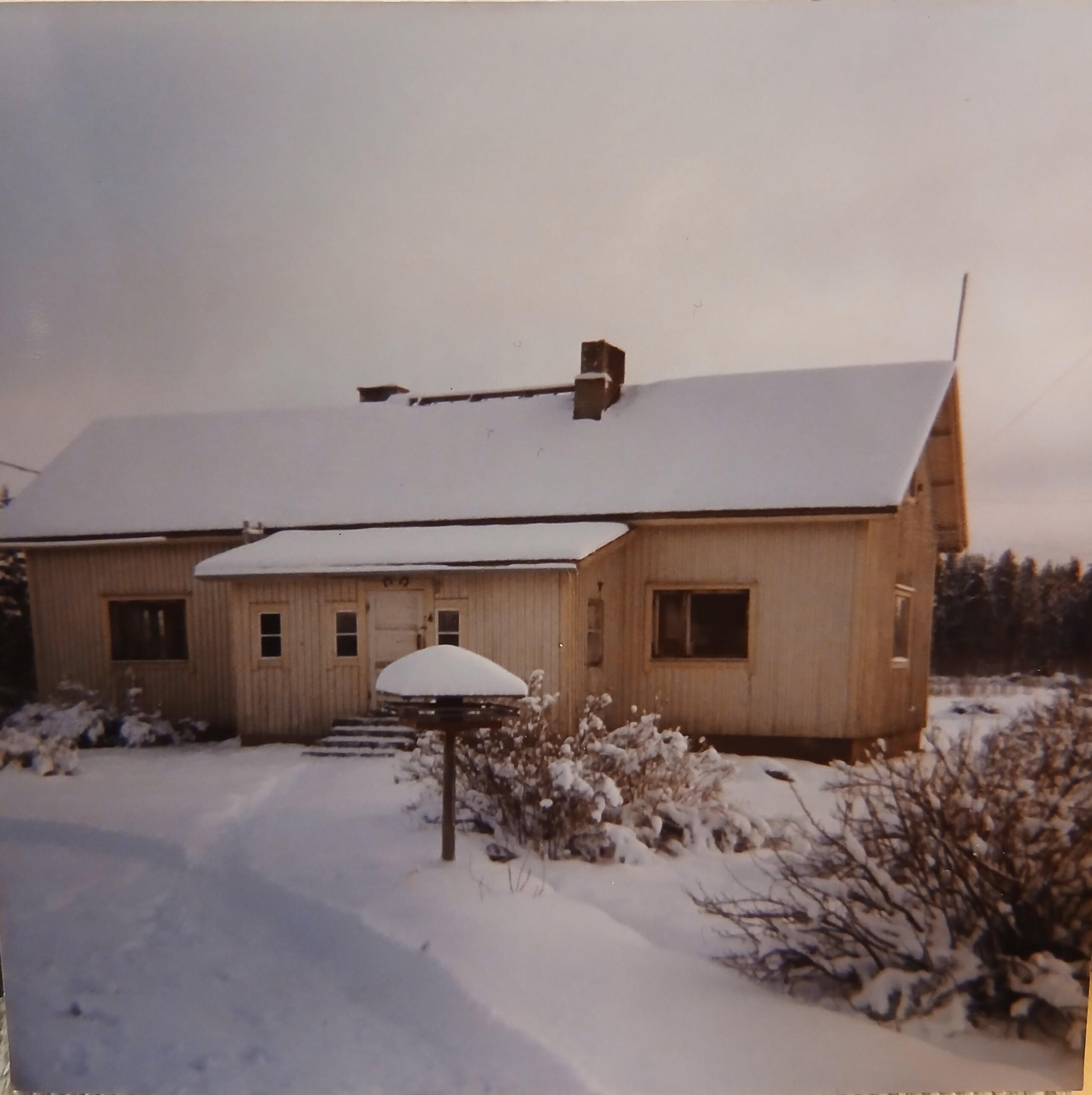 Keltainen talo lumen keskellä.